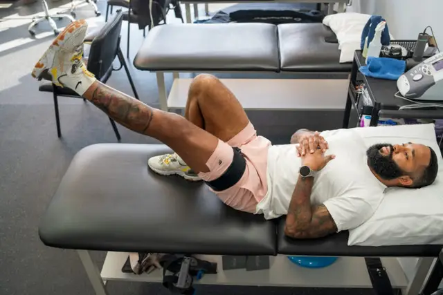 A patient doing a leg exercise on a treatment table in the Woodbridge clinic