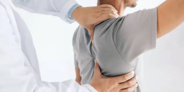 A chiropractor adjusting a patient's shoulder