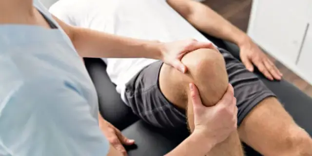 A physical therapist treating a patient's knee