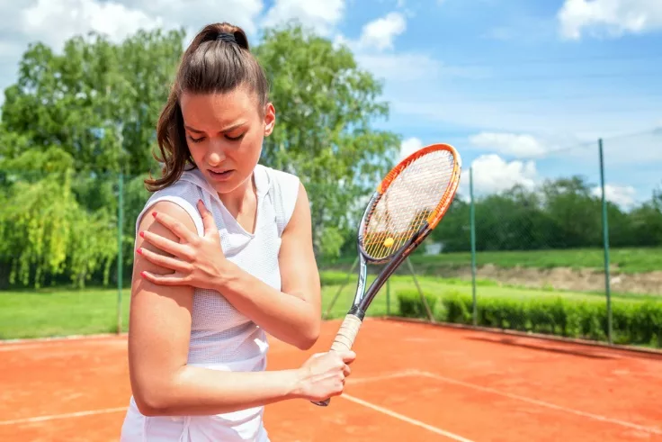 image of a woman playing tennis suffering from shoulder pain from a sports injury